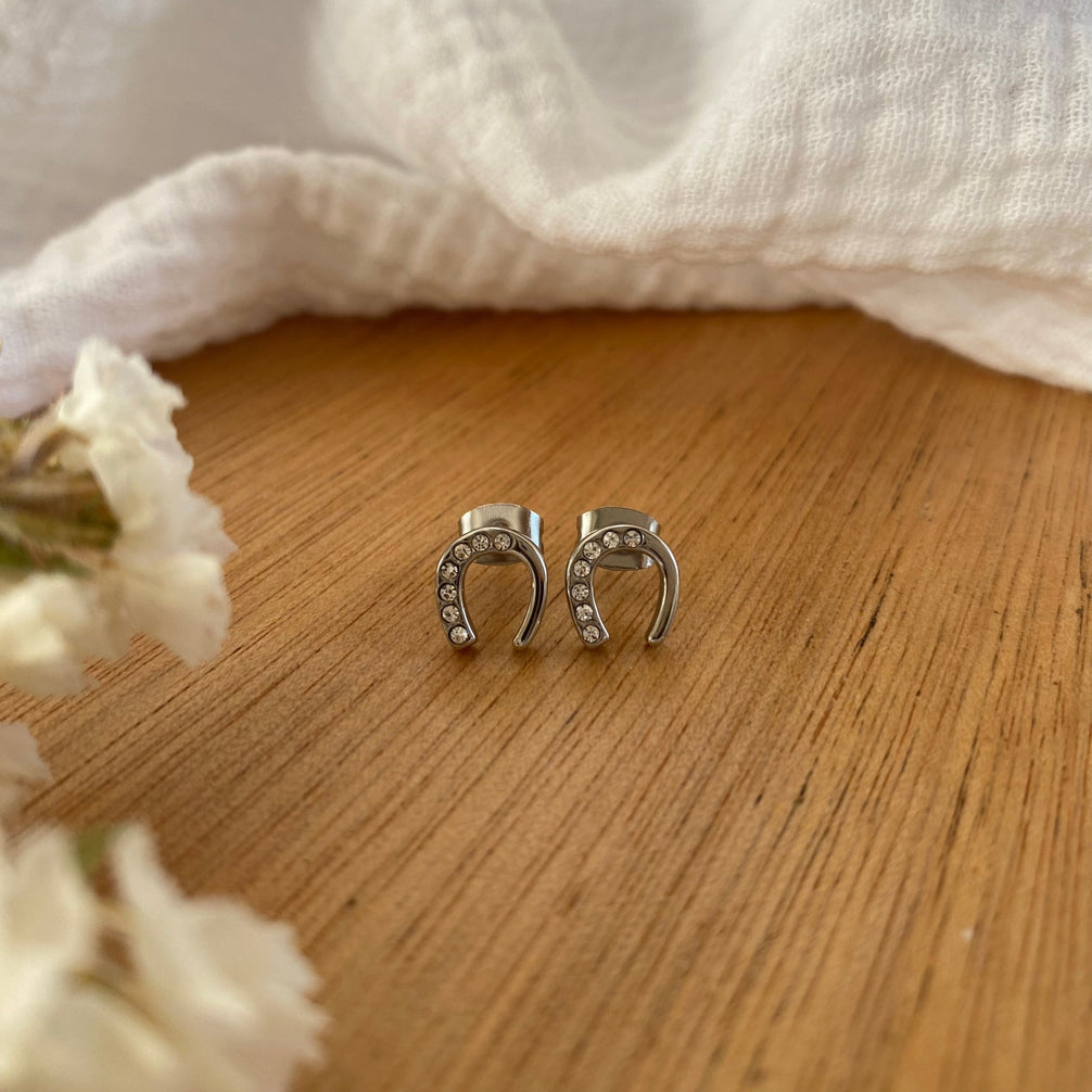 Equestrian Jewelry oorbellen Emy: hoefijzer-oorknopjes met strass-steentjes op één helft, in zilver of goud