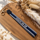 Equestrian Jewelry sleutelhanger Coach en or in stevig lint met geborduurde tekst en goudkleurige ringen